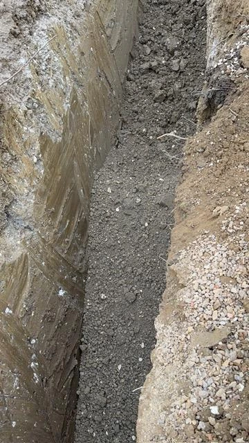 Modified material placed in a drainage trench